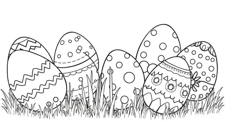Placa de huevos de Pascua decorados en blanco y negro entre la hierba.